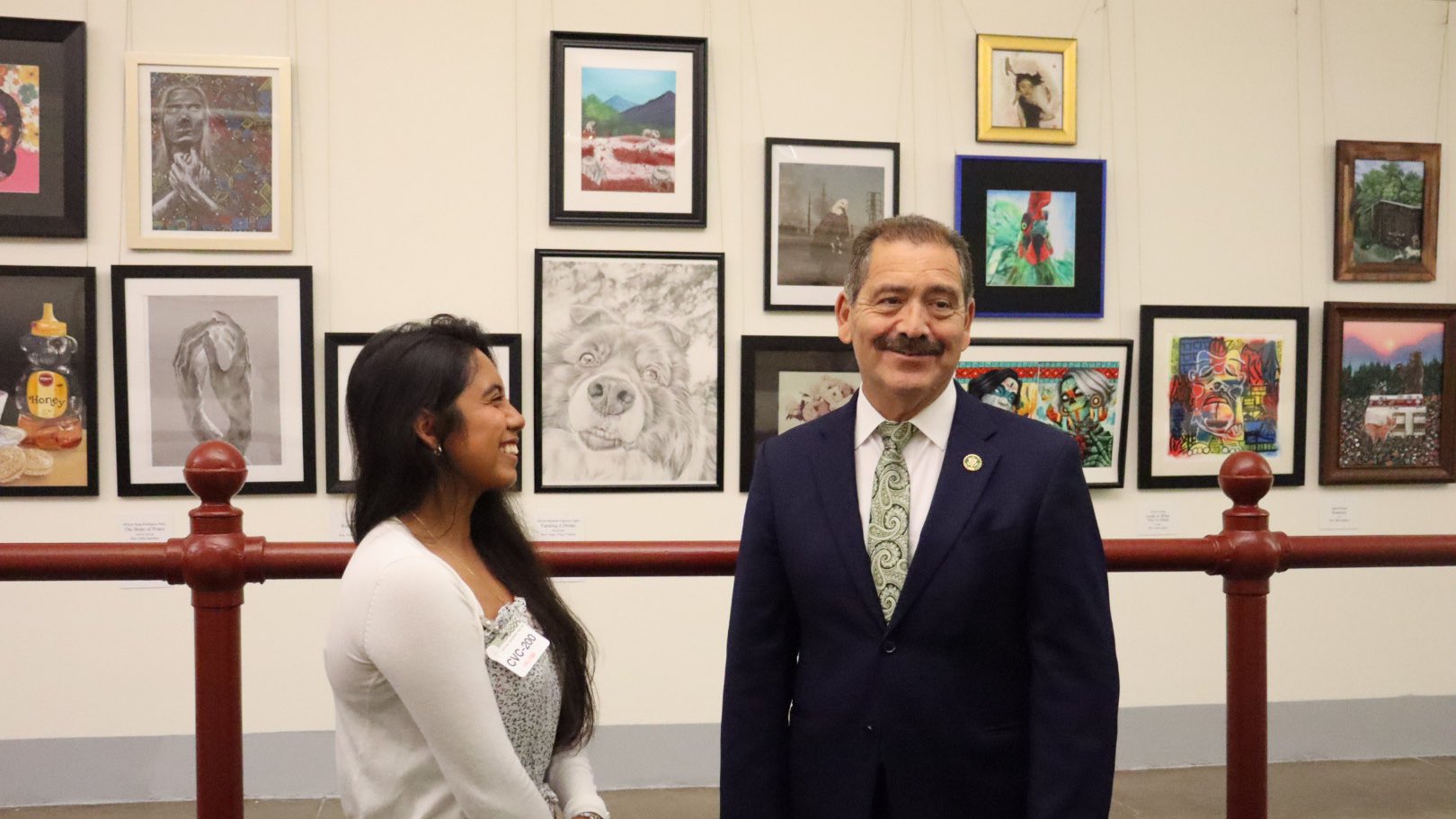 Congressman and Mariana smiling in front of her work